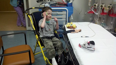 boy in wheeled chair engaging in adaptive play in a medical-setting